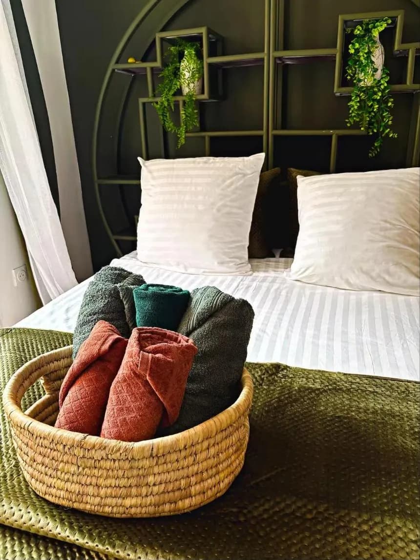 Panier de serviettes roulées posé sur le lit du Cabanon